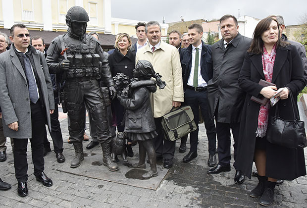 Депутаты региональных советов и представители делового сообщества Италии фотографируются у памятника «Вежливым людям» в Симферополе
