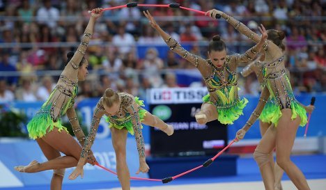 Российские спортсменки выполняют групповые упражнения с булавами