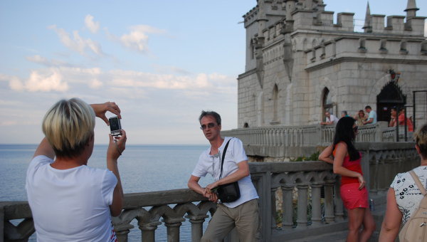 Туристы фотографируются на фоне Ласточкиного гнезда в Крыму. Архивное фото