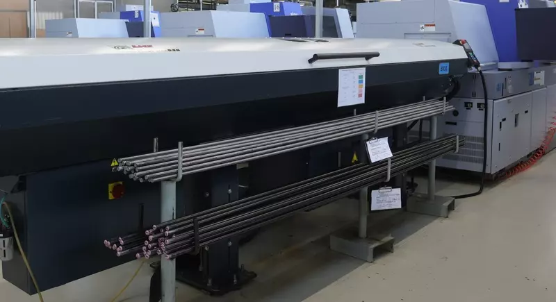 Прутки металла из разных сплавов сбоку от станка