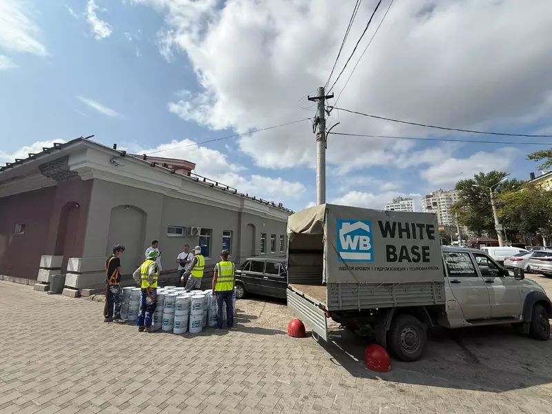 На фотот процесс выгрузки материала для работ - жидкая кровля